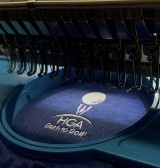 HGA golf logo being embroidered in a hoop