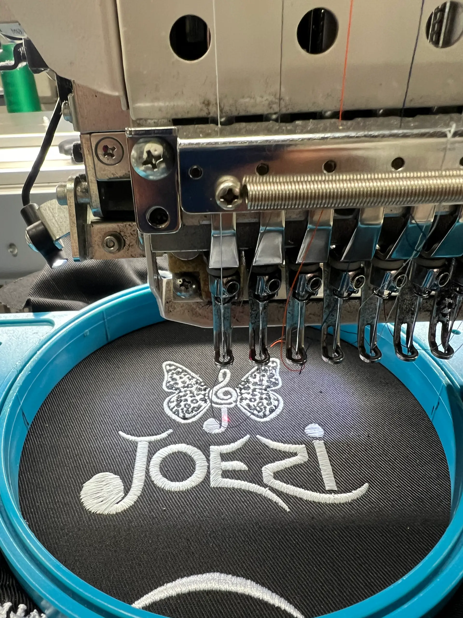Embroidery machine stitching a fine white line design